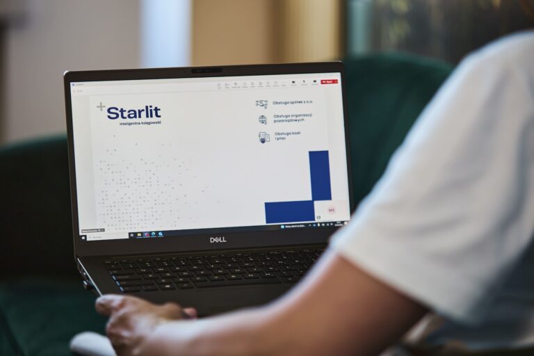 Laptop z prezentacją usług Starlit na ekranie